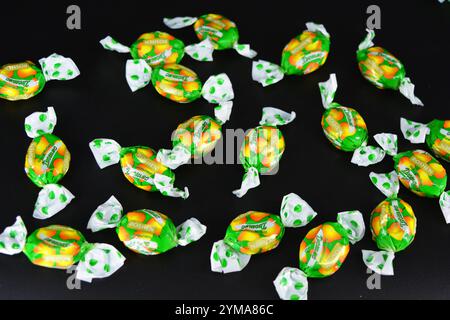 Nourriture, friandises, vacances, fêtes. Beaux bonbons aux fruits fabriqués à partir de jus et d'extrait de fruits emballés dans du polyéthylène coloré et brillant. Banque D'Images