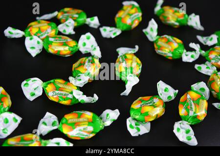 Nourriture, friandises, vacances, fêtes. Beaux bonbons aux fruits fabriqués à partir de jus et d'extrait de fruits emballés dans du polyéthylène coloré et brillant. Banque D'Images