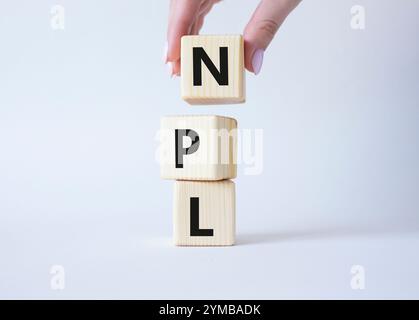 NPL - symbole de prêt non performant. Mot concept IPO sur cubes en bois. Main d'homme d'affaires. Beau fond blanc. Business et concept NPL. Copier l'espace Banque D'Images