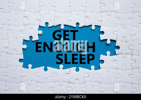 Symbole de sommeil suffisant. Puzzle blanc avec des mots obtenir assez de sommeil. Beau fond bleu. Mode de vie sain, médical et obtenir assez de sommeil concept. Banque D'Images