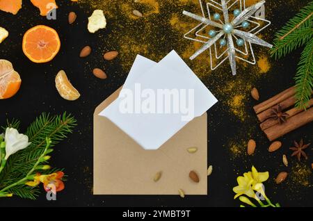 Carte vide et enveloppe - lettre de Noël à remplir avec le contenu, décorations savoureuses sur fond noir, vue de dessus. Banque D'Images