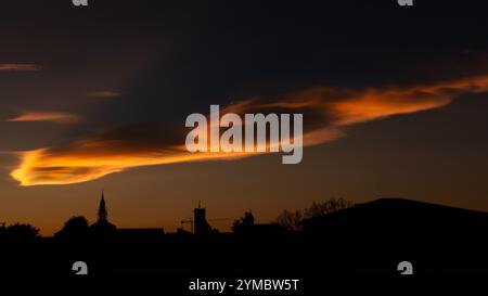 nuages irisés lors d'un beau coucher de soleil hivernal sur la ville. Banque D'Images