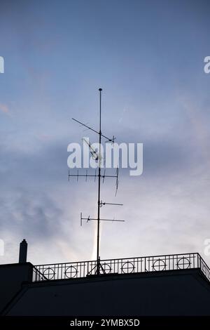 Ancienne antenne de capture de signal TV montée sur le toit d'un immeuble résidentiel en Europe. Vue à angle bas, pas de gens. Banque D'Images