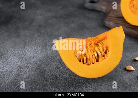 Citrouille orange fraîche entière et tranchée avec des graines sur un fond gris. Concept de cuisson. Copier l'espace. Banque D'Images