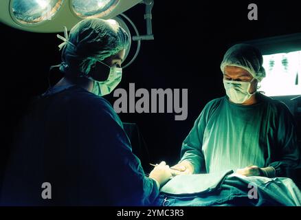 Chirurgie à l'hôpital Ibn al-bitar dans le district de Karkh à Bagdad, Irak. Au moment du tournage, vers 1985, l'hôpital était géré par PARC, une filiale d'Aer Lingus, pour le compte du gouvernement irakien. Il a fourni aux citoyens iraquiens un niveau élevé de soins, y compris des greffes et des chirurgies cardiaques, ainsi que d'autres procédures complexes. Des centaines de membres du personnel irlandais y travaillèrent dans tous les domaines d'activité, dont certains furent piégés à Bagdad pendant la première guerre du Golfe en 1991, ce qui mit fin à l'implication irlandaise. Près d'une cible militaire, il a été réduit à près de décombres par des bombardements en 2003. Banque D'Images