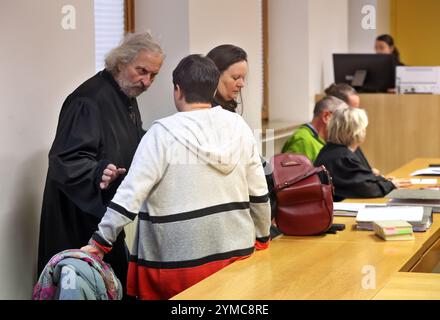 21 novembre 2024, Bavière, Schweinfurt : une femme accusée (2ème à partir de la gauche) et son mari (5ème à partir de la gauche), qui est également en procès, se tiennent debout et siègent avec leurs avocats dans une salle d'audience du tribunal de district. Près de deux ans après la mort présumée de leur fille par la faim, les parents accusés ont assumé la responsabilité de ce qui s'est passé. Selon le parquet, leur fille de 16 ans a contracté le coronavirus peu avant sa mort en décembre 2022 et souffrait d'une infection gastro-intestinale. Photo : Karl-Josef Hildenbrand/dpa - ATTENTION : personne(s) a/ont été pixélisée(s) Banque D'Images