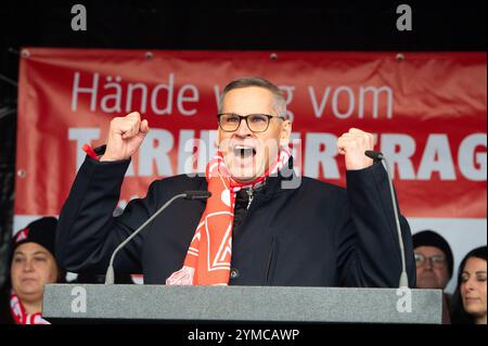 Wolfsburg, Allemagne. 21 novembre 2024. Thorsten Gröger, négociateur d’IG Metall, prend la parole lors d’un rassemblement. IG Metall souhaite la bienvenue aux représentants du Groupe au troisième tour de négociations collectives avec une forte protestation. Des milliers de participants manifestent devant l'usine sur le site de négociation de la Volkswagen Arena, suivie d'un rassemblement de protestation directement devant le stade. Crédit : Alicia Windzio/dpa/Alamy Live News Banque D'Images