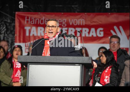 Wolfsburg, Allemagne. 21 novembre 2024. Thorsten Gröger, négociateur d’IG Metall, prend la parole lors d’un rassemblement. IG Metall souhaite la bienvenue aux représentants du Groupe au troisième tour de négociations collectives avec une forte protestation. Des milliers de participants manifestent devant l'usine sur le site de négociation de la Volkswagen Arena, suivie d'un rassemblement de protestation directement devant le stade. Crédit : Alicia Windzio/dpa/Alamy Live News Banque D'Images