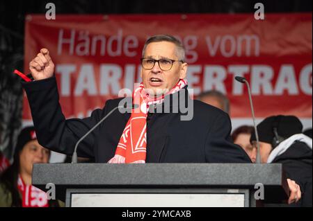 Wolfsburg, Allemagne. 21 novembre 2024. Thorsten Gröger, négociateur d’IG Metall, prend la parole lors d’un rassemblement. IG Metall souhaite la bienvenue aux représentants du Groupe au troisième tour de négociations collectives avec une forte protestation. Des milliers de participants manifestent devant l'usine sur le site de négociation de la Volkswagen Arena, suivie d'un rassemblement de protestation directement devant le stade. Crédit : Alicia Windzio/dpa/Alamy Live News Banque D'Images