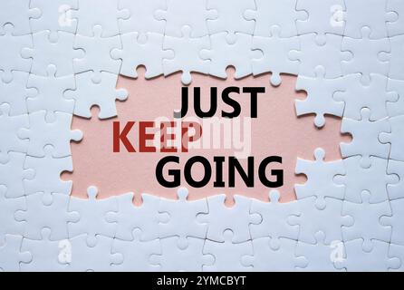 Symbole « continuez à aller ». Puzzle blanc avec des mots juste continuer. Beau fond rose. Business and Just Keep Go concept. Copier l'espace. Banque D'Images