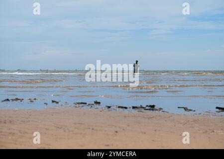 Un pêcheur est vu préparer son équipement de pêche tout en pêchant Banque D'Images