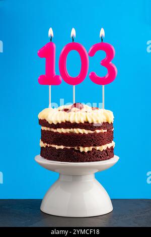 Anniversaire numéro 103 - bougie avec gâteau de velours rouge Banque D'Images