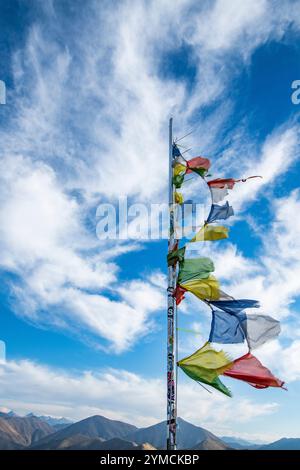 Drapeaux de prière flottant dans le vent au sommet de la montagne carbonate Banque D'Images