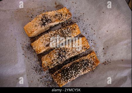 Tranches de saumon grillé avec sésame, assaisonnement et herbes sur papier parchemin pour la cuisson Banque D'Images