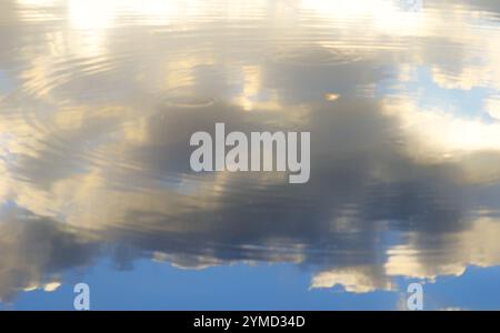 Reflet du ciel dans l'eau. Les nuages blancs comme la neige se reflètent dans l'eau bleue. Banque D'Images