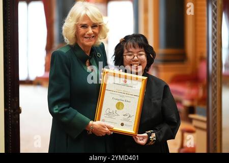 Queen Camilla avec Evangeline Khoo, lauréate senior, 15 ans, de Kuala Lumpur, Malaisie lors d'une réception pour les gagnants du concours de rédaction Queen's Commonwealth, au Buckingham Palace à Londres. Date de la photo : jeudi 21 novembre 2024. Banque D'Images