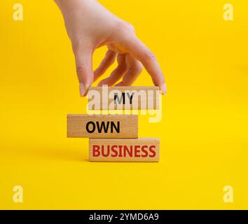 Symbole My Own Business. Mots conceptuels My Own Business sur des blocs de bois. Main d'homme d'affaires. Beau fond jaune Business et My Own Business con Banque D'Images