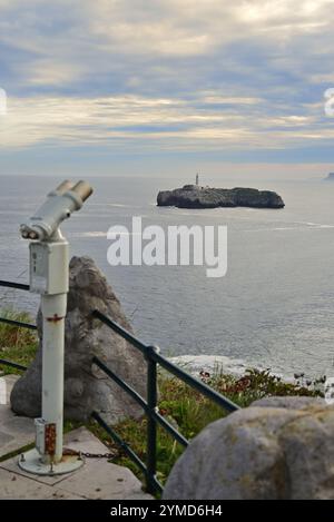 Jumelles en bord de mer donnant sur l'île de Mouro et le phare dans la baie de Santander, au nord de l'Espagne. Banque D'Images