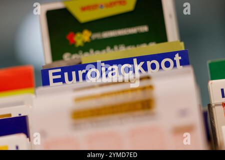 Cologne, Allemagne. 21 novembre 2024. Les billets EuroJackpot se tiennent sur une étagère dans un détaillant de loterie. Dans l'Eurojackpot, il y a encore 120 millions d'euros en jeu dans le tirage de vendredi pour les numéros gagnants. Après 13 tirages sans prix principal, il est toujours possible que le record de prix de loterie allemand soit battu. Crédit : Thomas Banneyer/dpa/Alamy Live News Banque D'Images