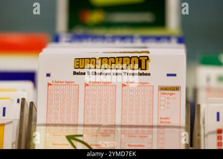 Cologne, Allemagne. 21 novembre 2024. Les billets EuroJackpot se tiennent sur une étagère dans un détaillant de loterie. Dans l'Eurojackpot, il y a encore 120 millions d'euros en jeu dans le tirage de vendredi pour les numéros gagnants. Après 13 tirages sans prix principal, il est toujours possible que le record de prix de loterie allemand soit battu. Crédit : Thomas Banneyer/dpa/Alamy Live News Banque D'Images