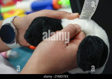 Nuremberg, Allemagne. 21 novembre 2024. Un expert en test de jouet tire sur les coutures d'un ours en peluche. TÜV Rheinland teste la sécurité des jouets dans son laboratoire d'essais de jouets depuis 70 ans. Crédit : Daniel Löb/dpa/Alamy Live News Banque D'Images