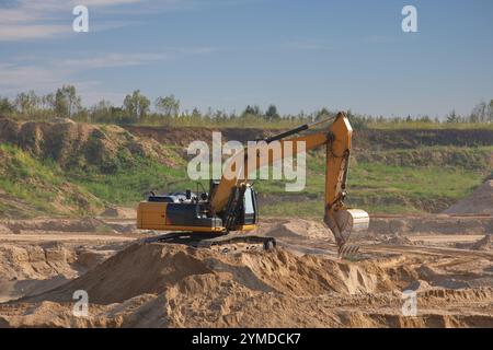 Excavatrice chargeuse effectuant des travaux de terrassement dans une carrière de sable Banque D'Images