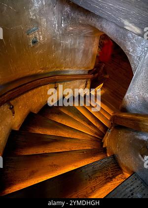 Un escalier avec une balustrade et une personne en arrière-plan. Les escaliers sont éclairés. La balustrade est en bois. Lettonie, Riga 08.10.2023 Banque D'Images