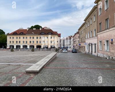 Une rue avec un bâtiment en arrière-plan. Le bâtiment a un toit rouge. Il y a des voitures garées dans la rue. Vieille ville, Pologne, Varsovie 29.05.2022 Banque D'Images