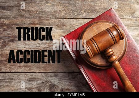 Loi sur les accidents de camion. Marteau du juge et livre sur la table en bois, vue de dessus Banque D'Images