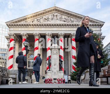 Londres, Royaume-Uni. 21 novembre 2024. Les colonnes à l'extérieur de la Royal Exchange à côté de la Banque d'Angleterre ont été ornées de rubans rouges pour donner l'impression de cannes géantes de bonbons de Noël. C'est la première fois que de telles décorations de Noël sont en place sur le bâtiment, apportant des couleurs attrayantes à la City de Londres. Credit : Stephen Chung / Alamy Live News Banque D'Images