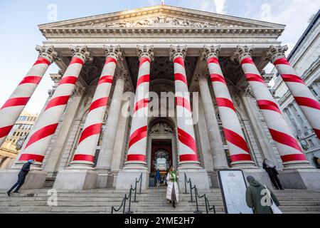 Londres, Royaume-Uni. 21 novembre 2024. Les colonnes à l'extérieur de la Royal Exchange à côté de la Banque d'Angleterre ont été ornées de rubans rouges pour donner l'impression de cannes géantes de bonbons de Noël. C'est la première fois que de telles décorations de Noël sont en place sur le bâtiment, apportant des couleurs attrayantes à la City de Londres. Credit : Stephen Chung / Alamy Live News Banque D'Images