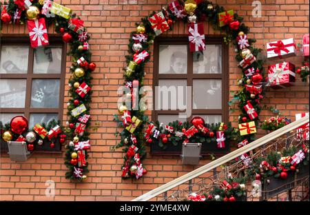 Les fenêtres de la maison sont décorées pour Noël. Décoration extérieure de Noël avec sapin de Noël artificiel et boules rouges avec boîtes Banque D'Images