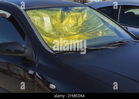 Intérieur de voiture protégé contre l'accumulation de chaleur avec pare-soleil en aluminium pliable et fenêtre ouverte du côté passager en été, Sibenik, Croatie Banque D'Images