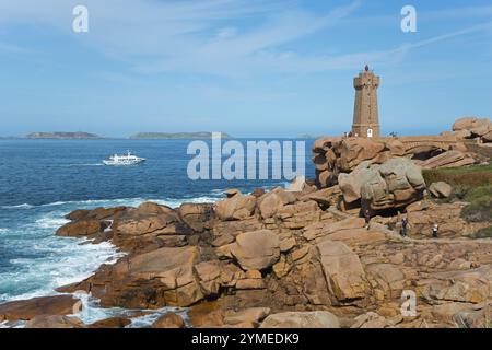 Bateau blanc naviguant le long de la côte rocheuse avec phare, Phare de Men Ruz, Ploumanac'h, Ploumanach, pointe de Squewel, Perros-Guirec, granit rose co Banque D'Images