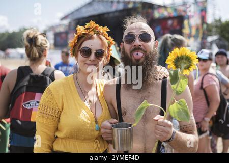 KOSTRZYN NAD ODRA, POLOGNE - 1 AOÛT 2019 : jeune couple heureux avec des tournesols pendant le festival de musique Pol'and'Rock Banque D'Images