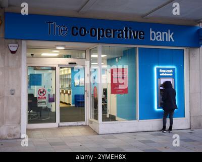 Succursale bancaire coopérative coopérative avec une personne à l'extérieur qui utilise le guichet automatique externe. Plymouth, Royaume-Uni Banque D'Images