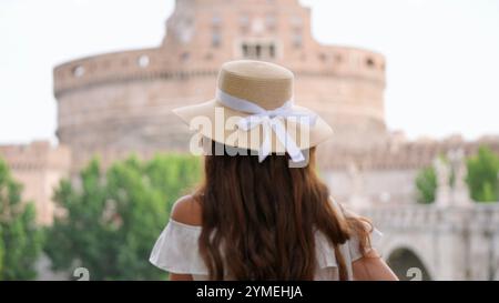 Femme en chapeau de paille admirant Castel Sant Angelo à Rome, Italie Banque D'Images