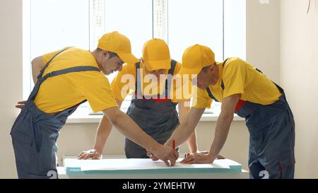 Brigade de la grande entreprise de construction discute du projet. Les ingénieurs regardent projet Banque D'Images