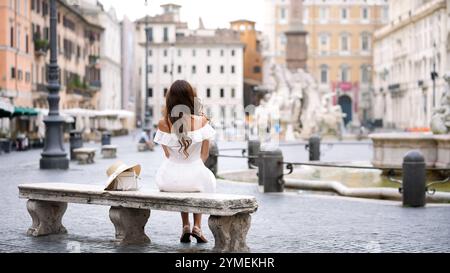 Belle scène d'une femme admirant les fontaines emblématiques de la Piazza Navona à Rome Banque D'Images