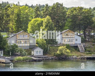 Deux maisons modernes en bois au bord de l'eau, nichées dans des forêts verdoyantes, archipel, stockholm, suède Banque D'Images