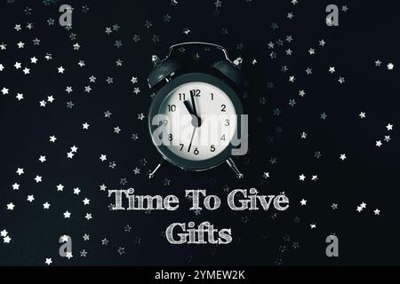 Photo en noir et blanc d'une horloge avec les mots Time to Give Gifts écrits en dessous Banque D'Images