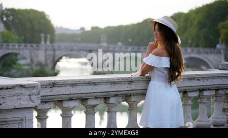 Femme gracieuse regardant le Tibre et le pont romain à Rome Banque D'Images