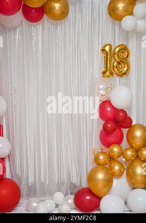 Ballons multicolores lumineux pour un anniversaire de dix-huit ans. Une bannière festive avec le numéro 18. Le dix-huitième anniversaire Banque D'Images