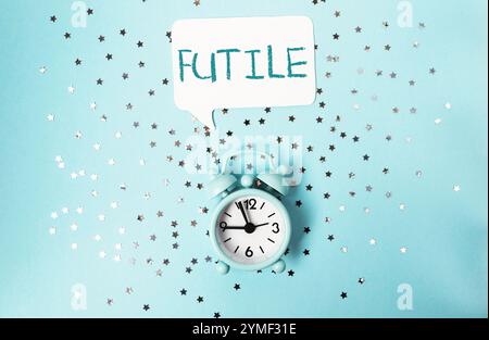 Horloge avec le mot futile écrit au-dessus. L'horloge est réglée à 11h45 Banque D'Images