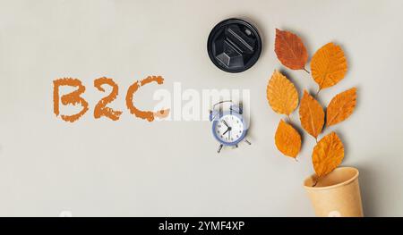 Horloge et une tasse sont sur une table avec le mot B2C écrit en orange. Concept de temps et d'affaires Banque D'Images