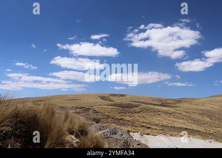 Vue d'un paysage montagneux au Pérou Amérique du Sud avec une végétation morte et un ciel bleu clair avec des nuages Banque D'Images