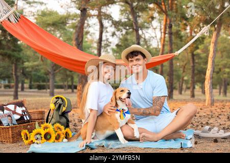 Jeune couple avec chien Beagle sur pique-nique dans la forêt Banque D'Images