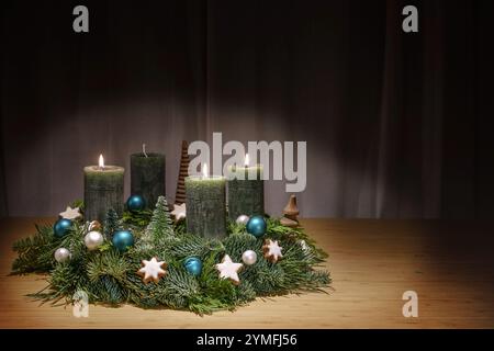 Couronne de l'Avent avec des bougies vert foncé, le troisième est allumé, décoration de Noël, boules et étoiles de cannelle, table en bois, décoration de vacances, copie spac Banque D'Images