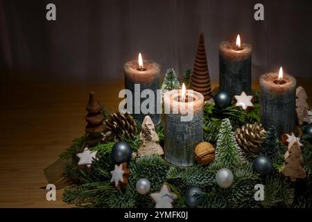 Couronne de l'Avent avec quatre bougies brunes allumées et décoration de Noël comme des boules, des cônes et des étoiles de cannelle sur un fond sombre, espace de copie, selec Banque D'Images