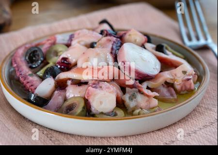 Savoureux antipasti salade ou plat de fruits de mer, poulpe grillé style ligure avec olives vertes et noires servies dans le restaurant italien Banque D'Images